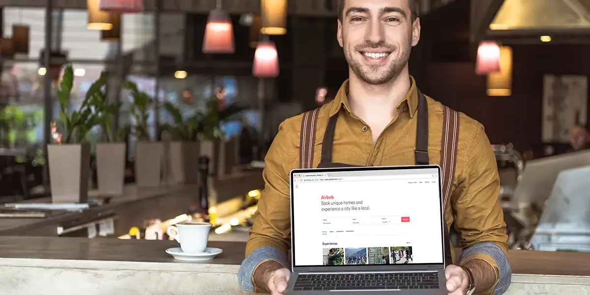 proprietaire-optimisation-airbnb Propriétaire devant son annonce Airbnb